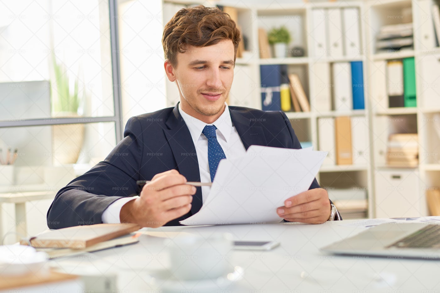 Businessman Reading Document In...: Stock Photos