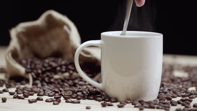 Stir the hot coffee in a cup with a spoo, Stock Video