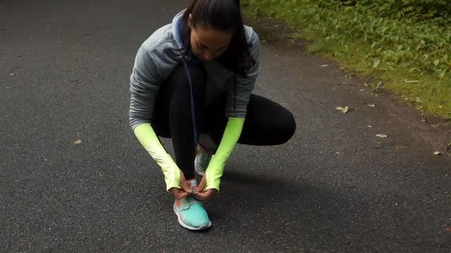 Woman Runner Tying Shoelaces: Stock Video