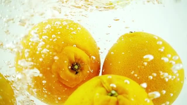 Four Oranges Dropped Into Water: Stock Video