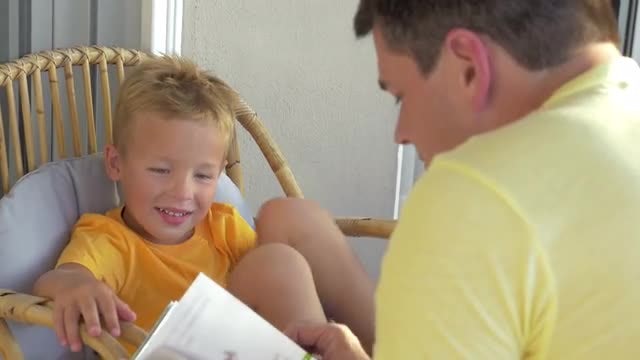 Boy Listening To Father Reading: Stock Video