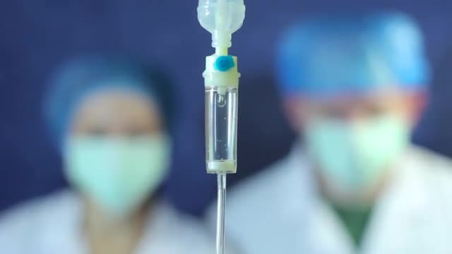 Intravenous Drip With Doctors Behind: Stock Video