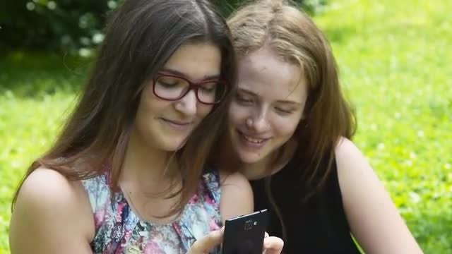 Teenage Girls Using Smartphone Outdoors: Stock Video