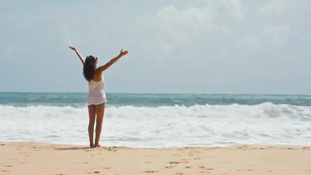 Woman lifts hands up on the sea background: Stock Video