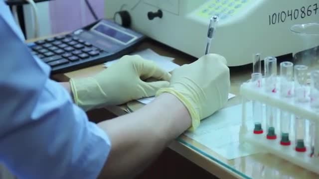Doctor Using Calculator And Notebook: Stock Video