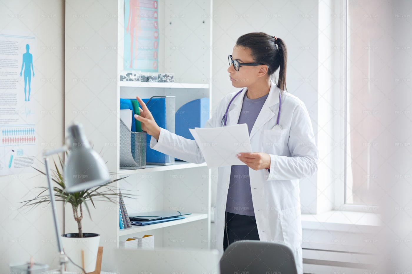 Female Doctor Filing Documents: Stock Photos