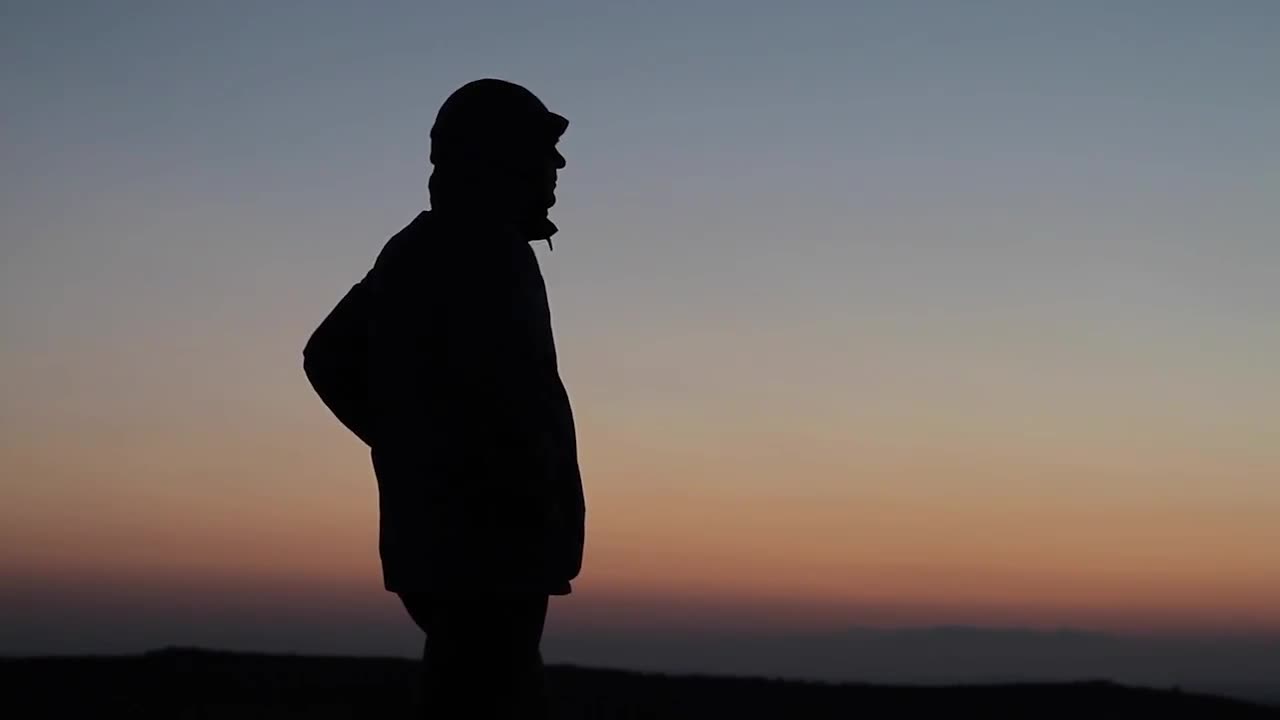 Silhouetted Man Gazing Off Mountain - Stock Video 