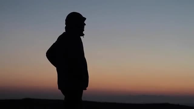Silhouetted Man Gazing Off Mountain : Stock Video