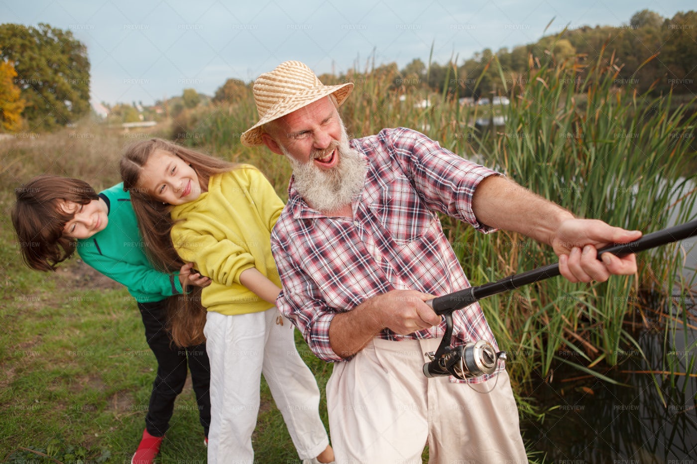Kids And Grandpa Pulling A Fish In: Stock Photos