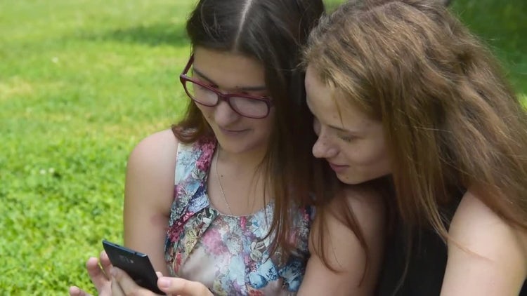 Teenage Girls Using Cellphone Outdoors: Stock Video