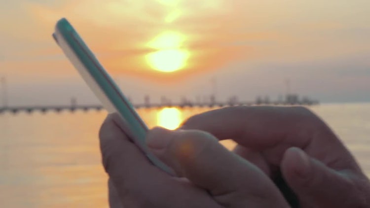 Typing On Smartphone At Sunset: Stock Video