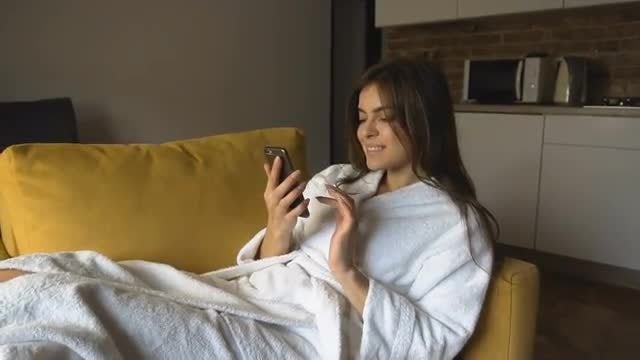 Woman Uses Phone Lying In Armchair: Stock Video