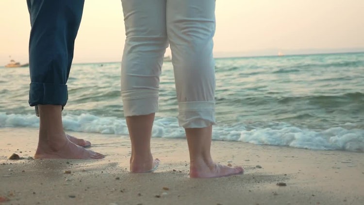Couple Standing Barefoot On Beach: Stock Video