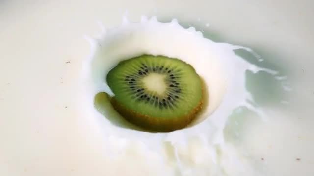Kiwi Dropped Into Milk: Stock Video