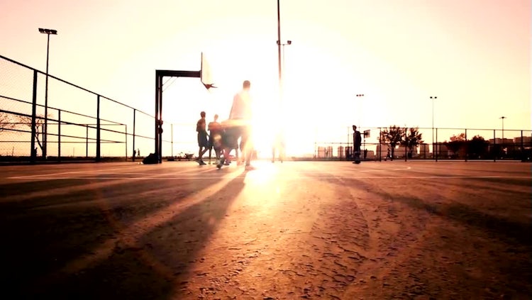 Men Playing Basketball At Sunset: Stock Video