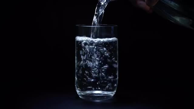 Pouring Water Into Glass Bottle: Stock Video