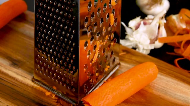 Premium Photo  Shredding grater and shredded carrots on a cutting