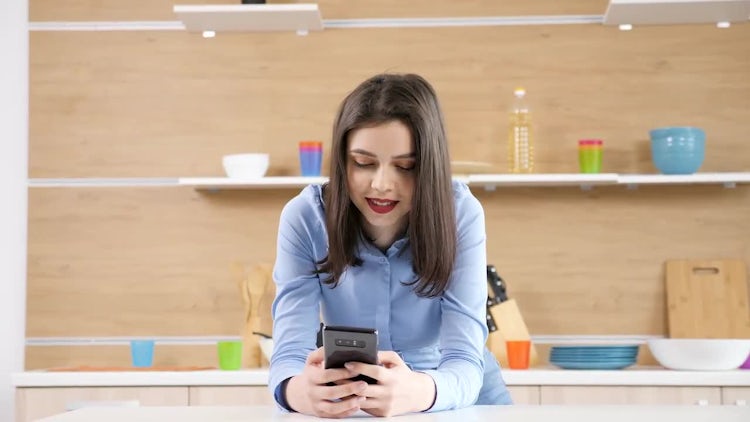 Woman Using Smartphone In Kitchen: Stock Video