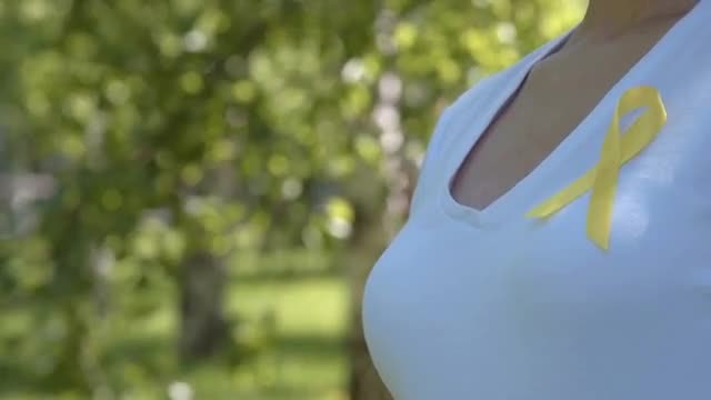 Woman Wearing Yellow Awareness Ribbon: Stock Video