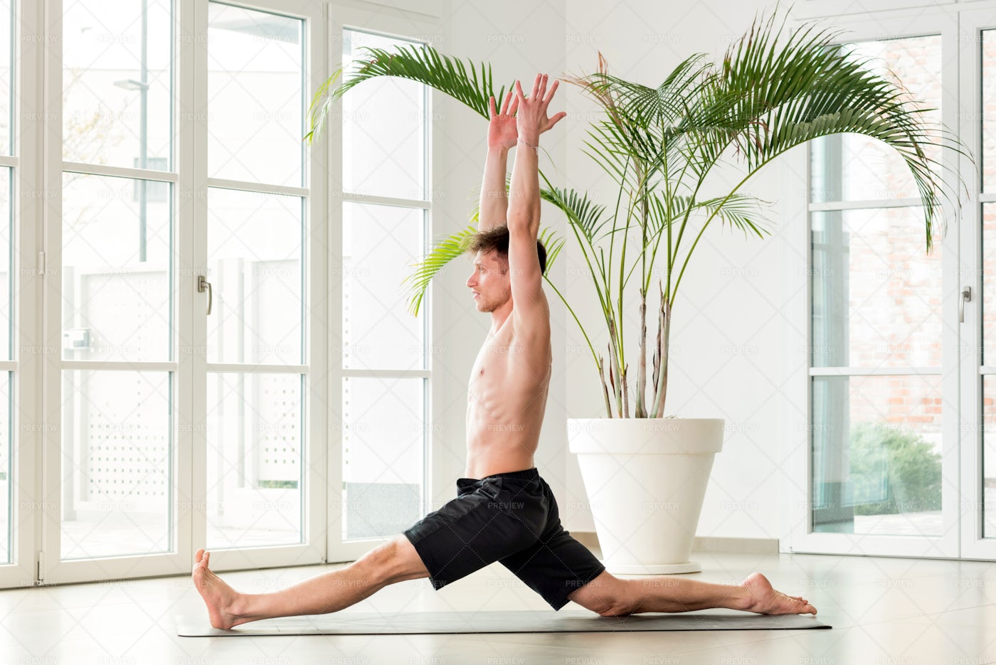 Man Performing Monkey Yoga Pose: Stock Photos