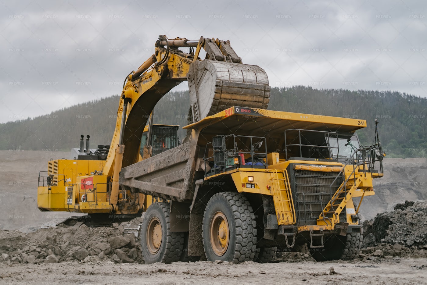 An Excavator Loads Ore Into A Dump Truck: Stock Photos