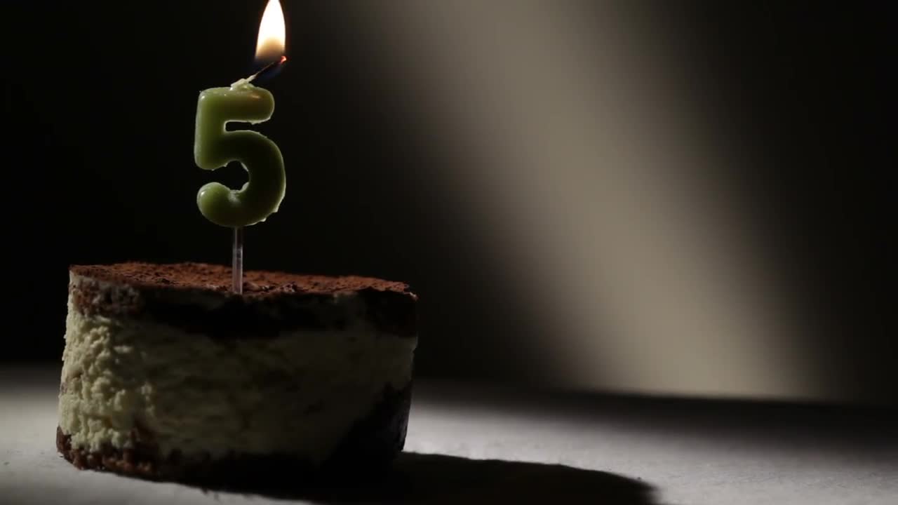 Birthday cake with 77 number candle on blue backgraund set on fire by  lighter. Close-up view Stock Photo by ©Stasonych 338939766