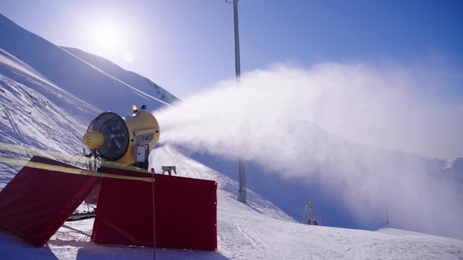 Artificial snow machine cannon or snow blower making snowflakes. Snow-gun  spraying artificial ice crystals. Winter ski resort - popular travel  destination Stock Photo