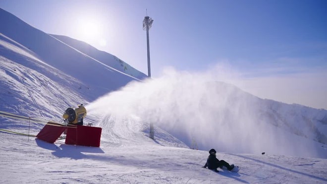 Snow cannon, machine or gun snowing the slopes or mountain for skiers ans  snowboarders, artificial snow Stock Photo
